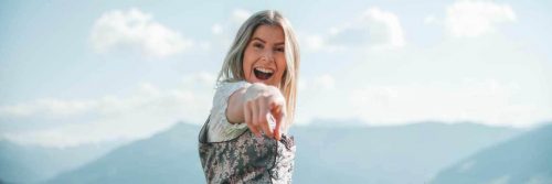 woman happy face points in cloudy sky