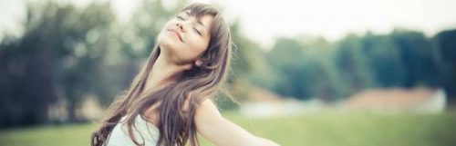 woman eyes closed raises hands gratitude life on field