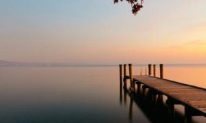 sea cliff peaceful lake in sunset sky