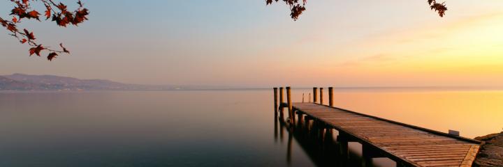 sea cliff peaceful lake in sunset sky