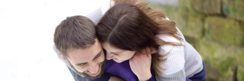 man carries girlfriend on back talking smiling