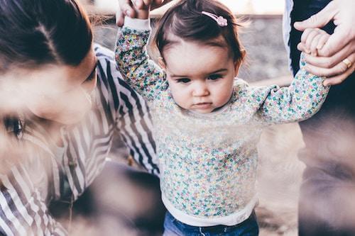 parent caring for child learning to walk