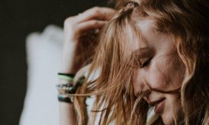 woman sits hand on head feeling stressed