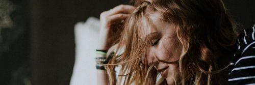 woman sits hand on head feeling stressed