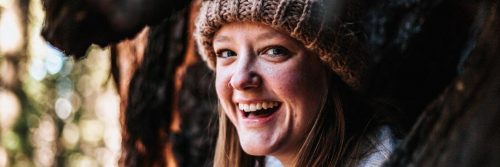 woman wearing hat smiles