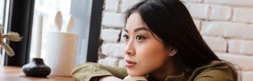 young woman sitting hands on table thinking