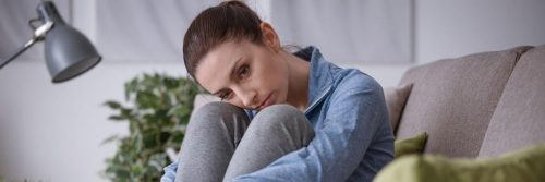 woman sitting head on knee feeling sad guilty worrying