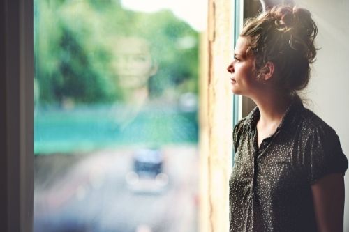 Middle aged woman staring out the window, changing her perspective