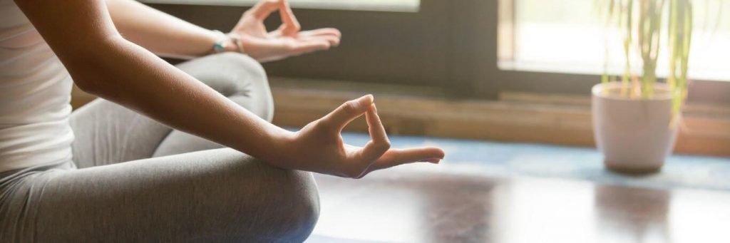 woman sits legs crossed practices meditation