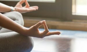 woman sits legs crossed practices meditation