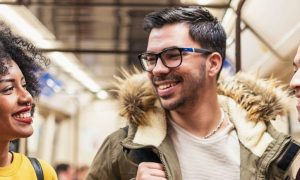 group of friends happily smiling talking in public train station