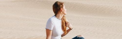 woman sits on desert enjoying weather