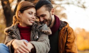 couple happy faces sit in park smiling