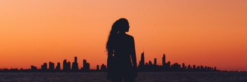 woman shadow facing backward standing in field red clear sky