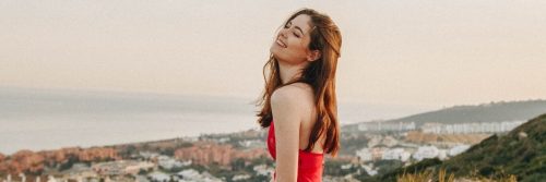 young woman happy face stands on rock feeling grateful about life