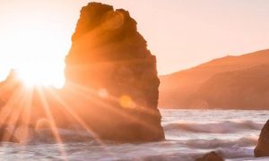 waves ocean between rocks in shining sun