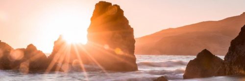 waves ocean between rocks in shining sun