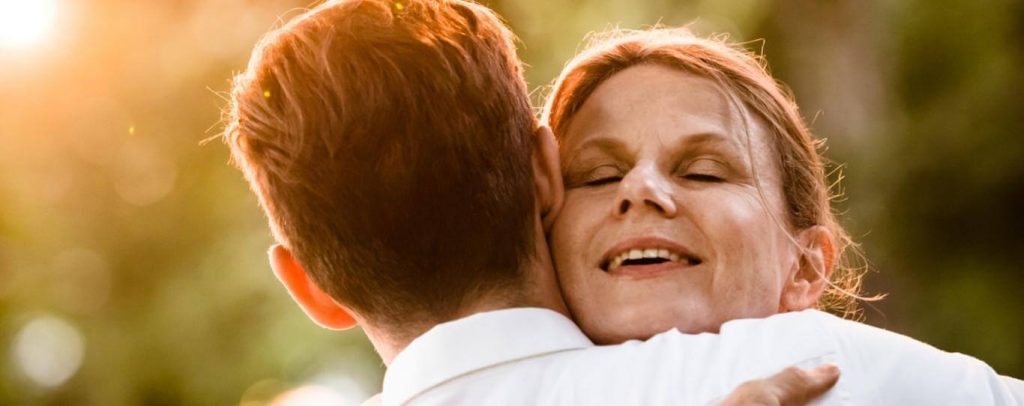 old woman satisfied hugging son