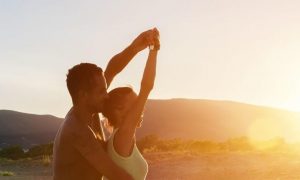 couple dances aerobics on field in sunny sky