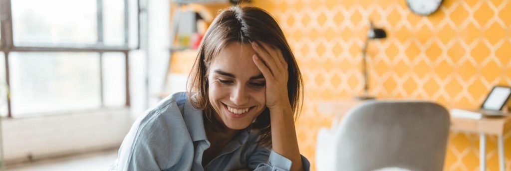 short hair woman sits in private study room happily smiling