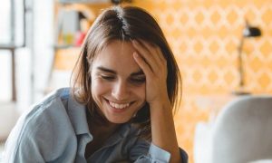 short hair woman sits in private study room happily smiling