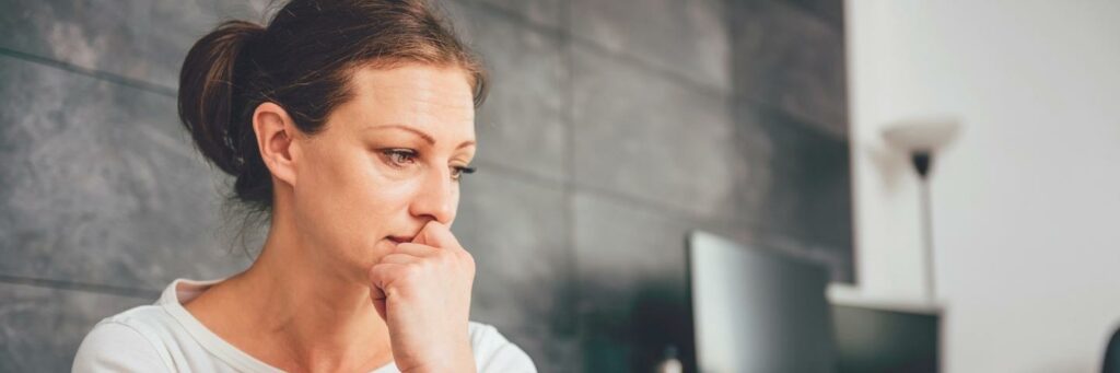 Sad woman sitting on a sofa in the living room