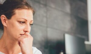 Sad woman sitting on a sofa in the living room