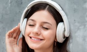 young woman wearing headphone enjoying listening to music