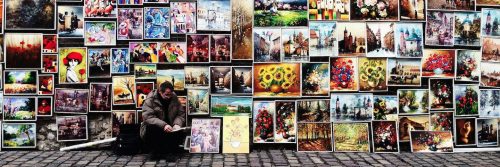 man sits beside painting art gallery