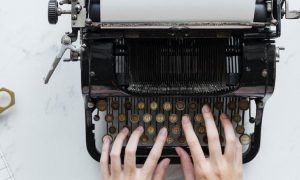 hands typing on traditional printer