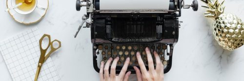 hands typing on traditional printer