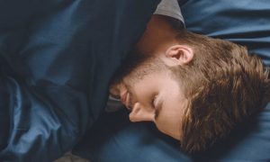 man sleeps tight on bed