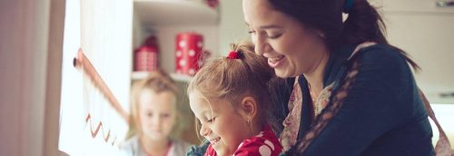 woman happily takes care of kids in kindergarten