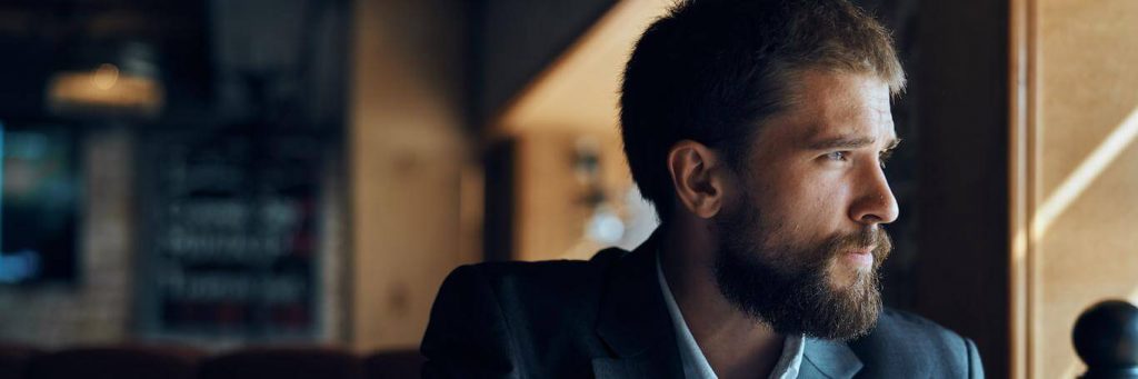 businessman sits in shop looking thinking