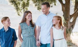 happy family walks in park smiling enjoying joyful moment while parents holding hands