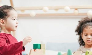 two girls play lego jigsaw puzzle