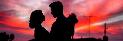 couple shadow hugging looking at each other in dark red sky