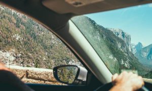 person driving car along footpath looking at mountain