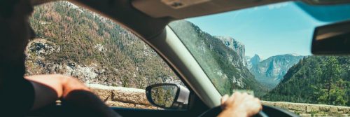 person driving car along footpath looking at mountain