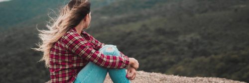 woman sits on rock in peaceful environment