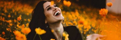 woman stands in beautiful garden happily laughing blissing