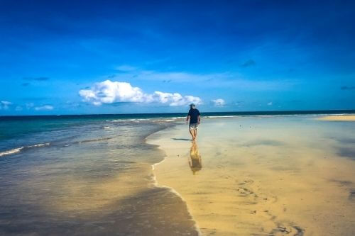 Man being present walking along the beach.