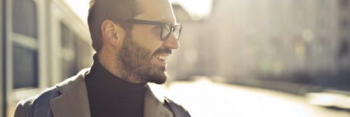 man walks on street happily smiling