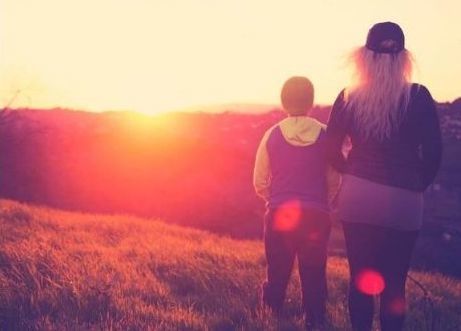 Mother walking through a field wit h her young son