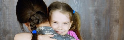 daughter hair tied with blue band happily smiles hugs mom