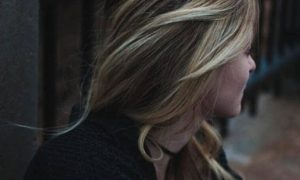 woman stands near fence thinking