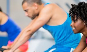 group of mixed gender training energetically on biking machine