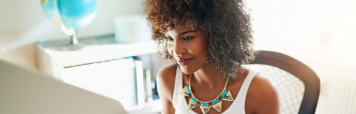 curly hair woman happy face sitting in bright office room small white bookshelf