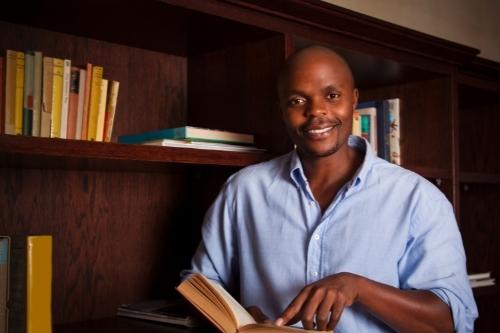 Man in library holding a book