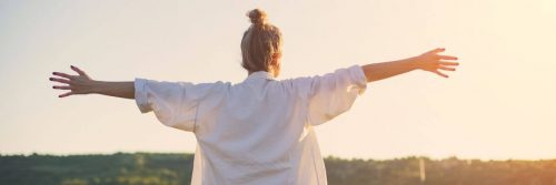 woman facing backward gratitude life in sunny sky